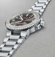Orologio subacqueo in acciaio con quadrante grigio e bracciale a maglie, datario.