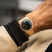 Orologio subacqueo bronzo con quadrante nero sul polso, bracciale a maglie