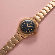 Orologio subacqueo bronzo con quadrante nero e bracciale a maglie, vista dall’alto