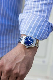 Orologio subacqueo in acciaio con quadrante blu e bracciale a maglie al polso
