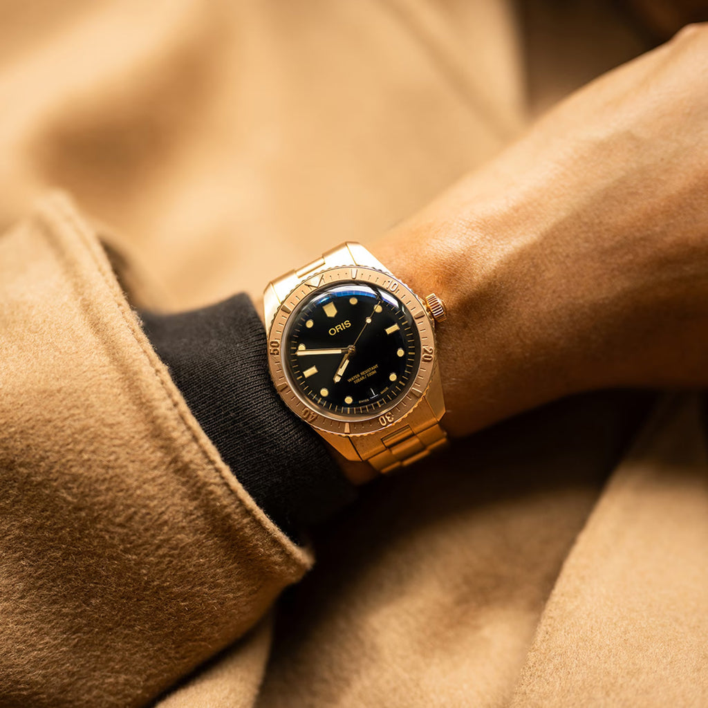 Orologio sub al polso: cassa bronzo, quadrante nero con cornice blu e indici