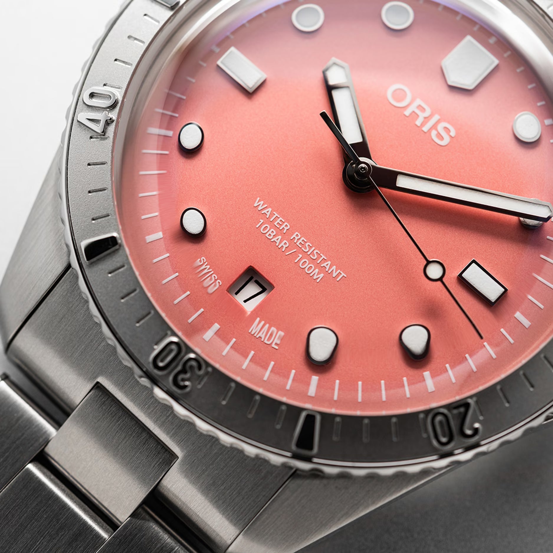Quadrante rosa dell’orologio Oris con lancette, indici luminosi e datario