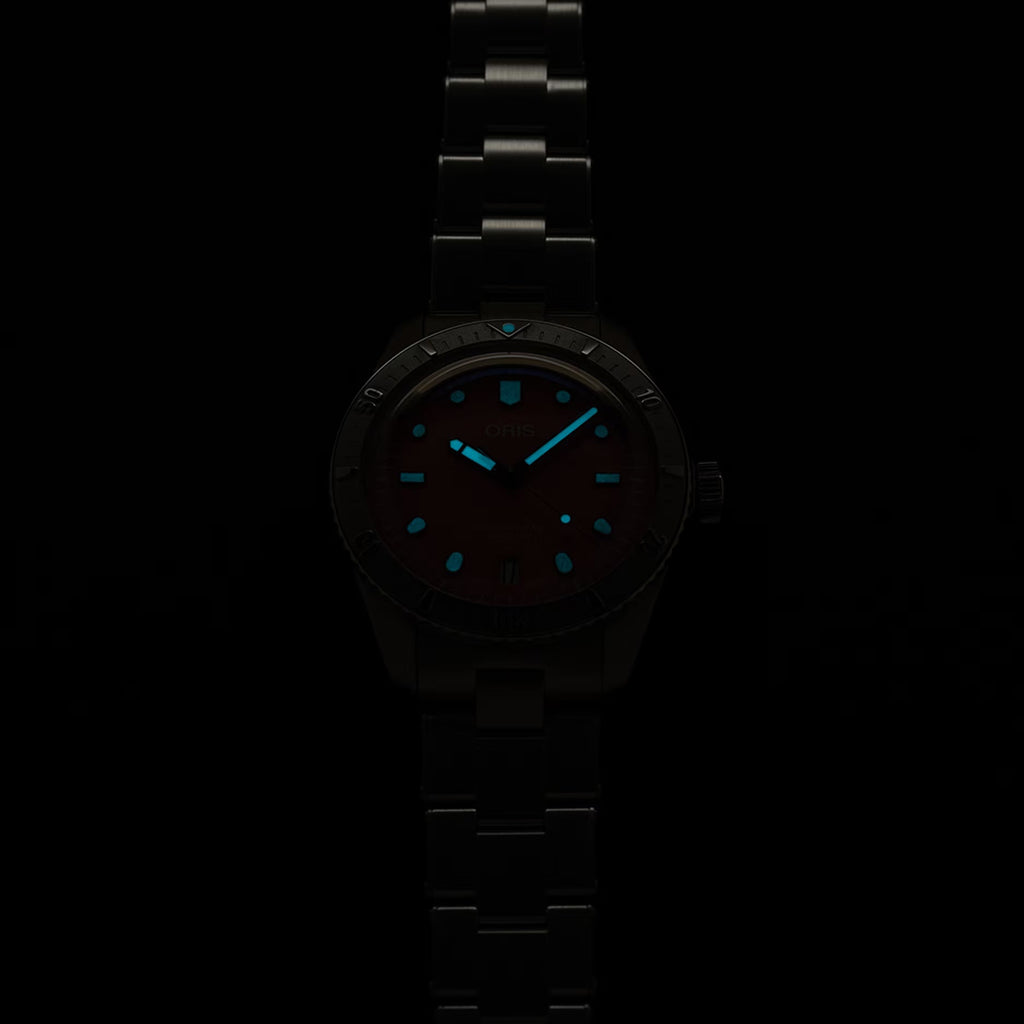 Orologio ORIS con quadrante scuro e indici blu, bracciale in acciaio scuro.