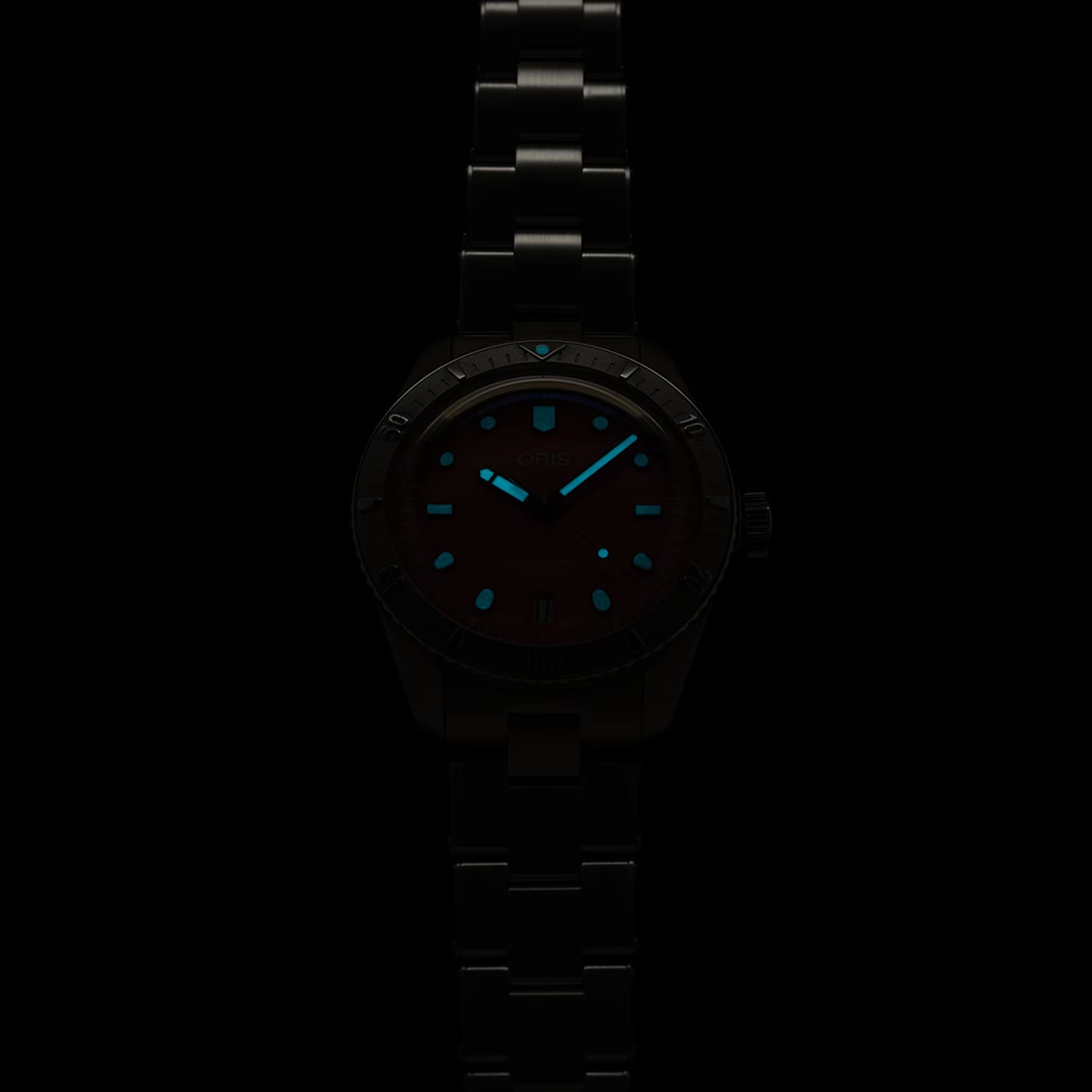 Orologio ORIS con quadrante scuro e indici blu, bracciale in acciaio scuro.