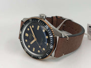 Orologio sub con lunetta nera e cassa acciaio/bronzo, quadrante blu scuro e cinturino pelle.