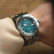 Orologio subacqueo al polso con quadrante verde acqua e bracciale in maglia metallica