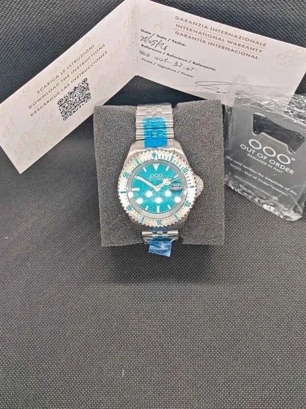 Orologio subacqueo con quadrante blu-verde su scatola, bracciale in acciaio e maglie blu