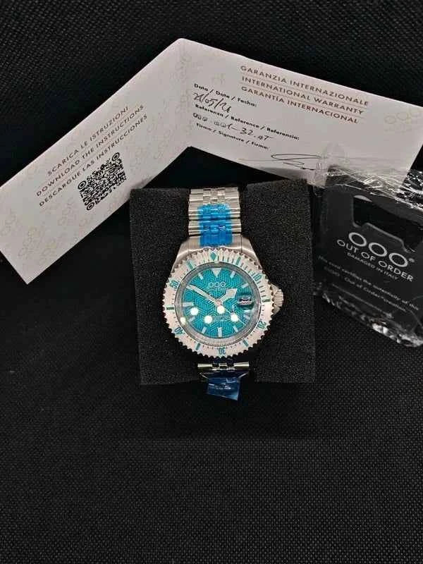 Orologio subacqueo con quadrante verde e bracciale in maglia metallica, dettagli aztechi