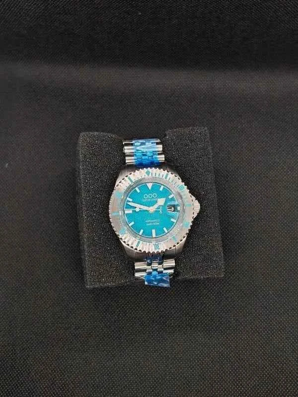 Orologio subacqueo con quadrante blu-verde, ghiera dentata e bracciale in acciaio