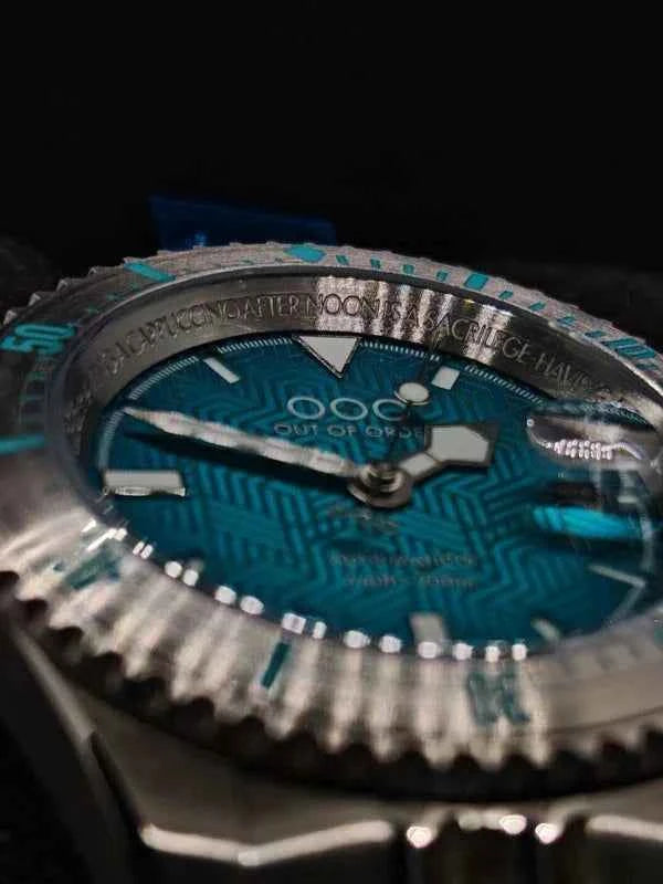 Quadrante dell’orologio subacqueo blu-verde con indici luminosi e scritta OOO