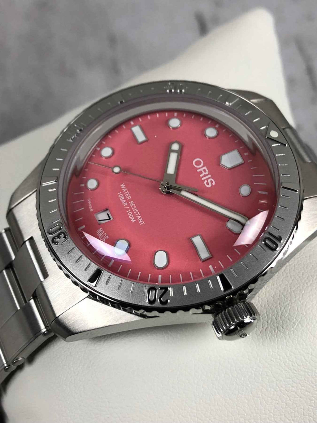 Orologio subacqueo ORIS con quadrante rosso e bracciale in acciaio, indici applicati.
