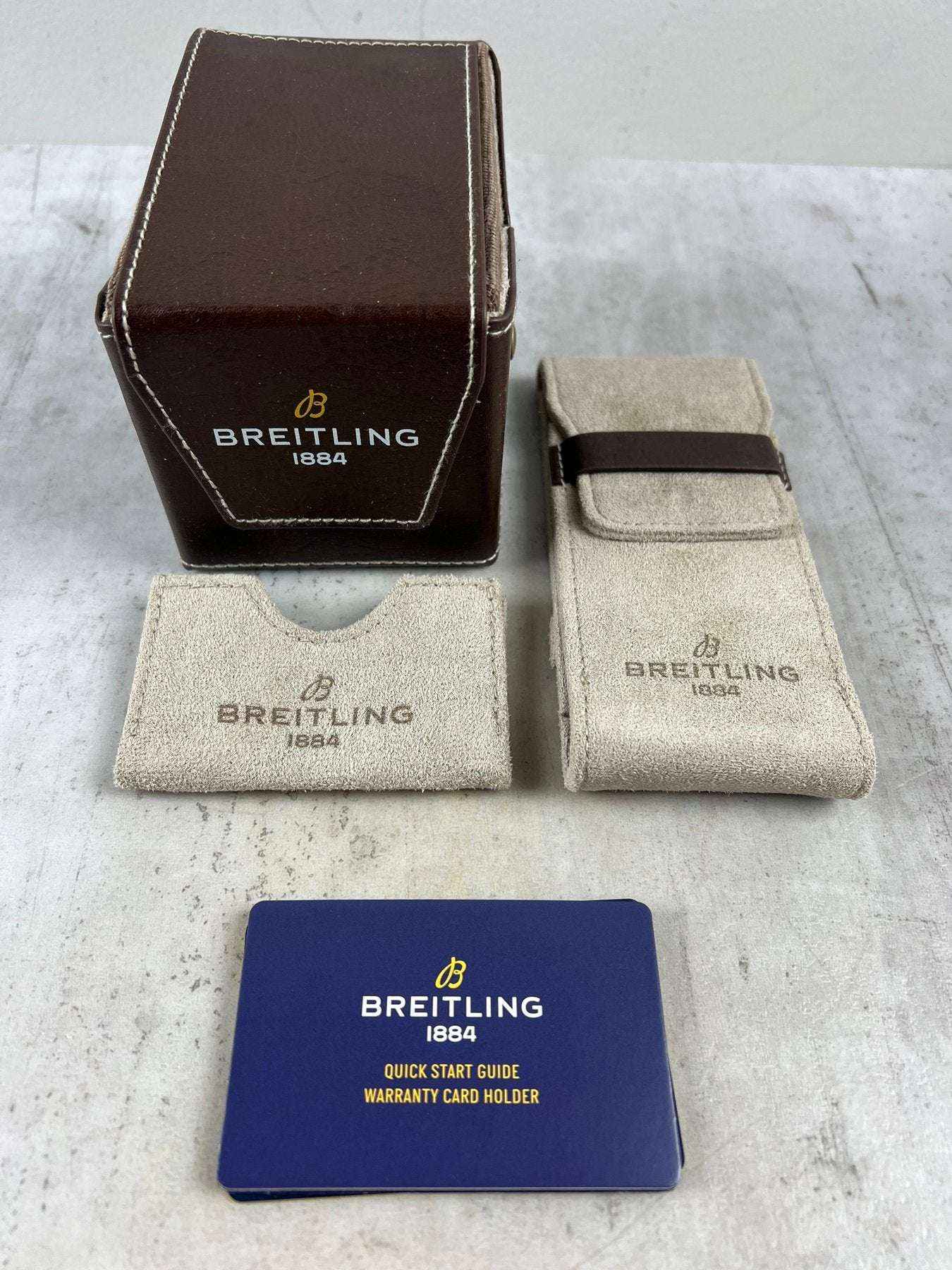 Accessori Breitling: scatola marrone, custodia beige e card blu