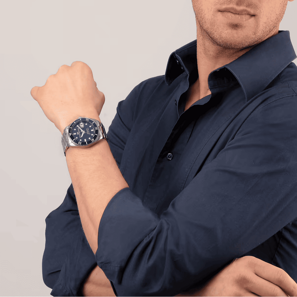 Orologio subacqueo su polso con quadrante blu e bracciale in acciaio, su camicia
