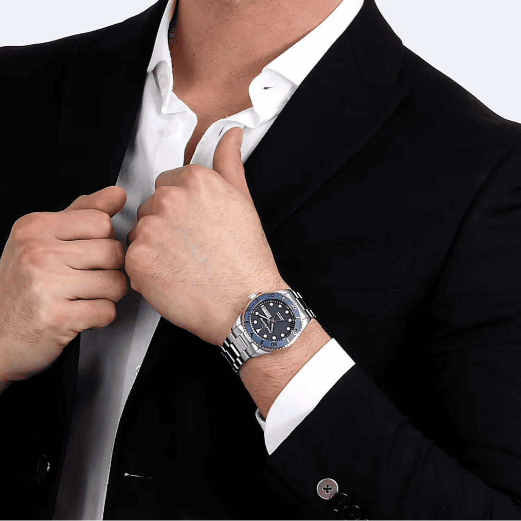 Orologio al polso: quadrante blu con indici, bracciale e cassa in acciaio.
