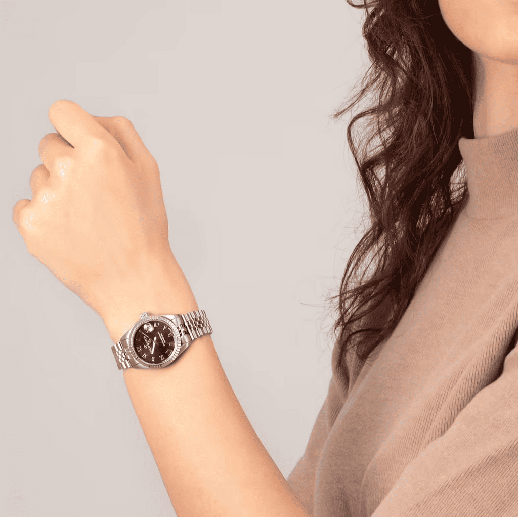Orologio da donna al polso con quadrante nero e bracciale in maglia d’acciaio
