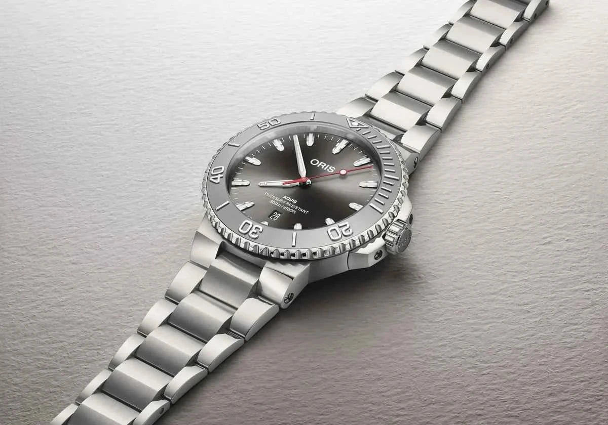 Orologio subacqueo in acciaio con quadrante grigio, ghiera con indici e bracciale maglie