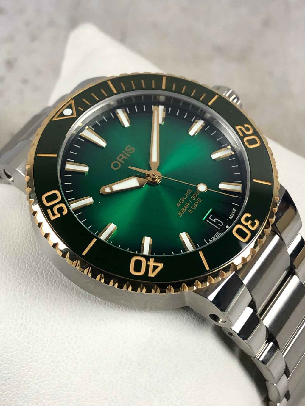 Orologio subacqueo ORIS con quadrante verde, ghiera oro e cinturino in acciaio