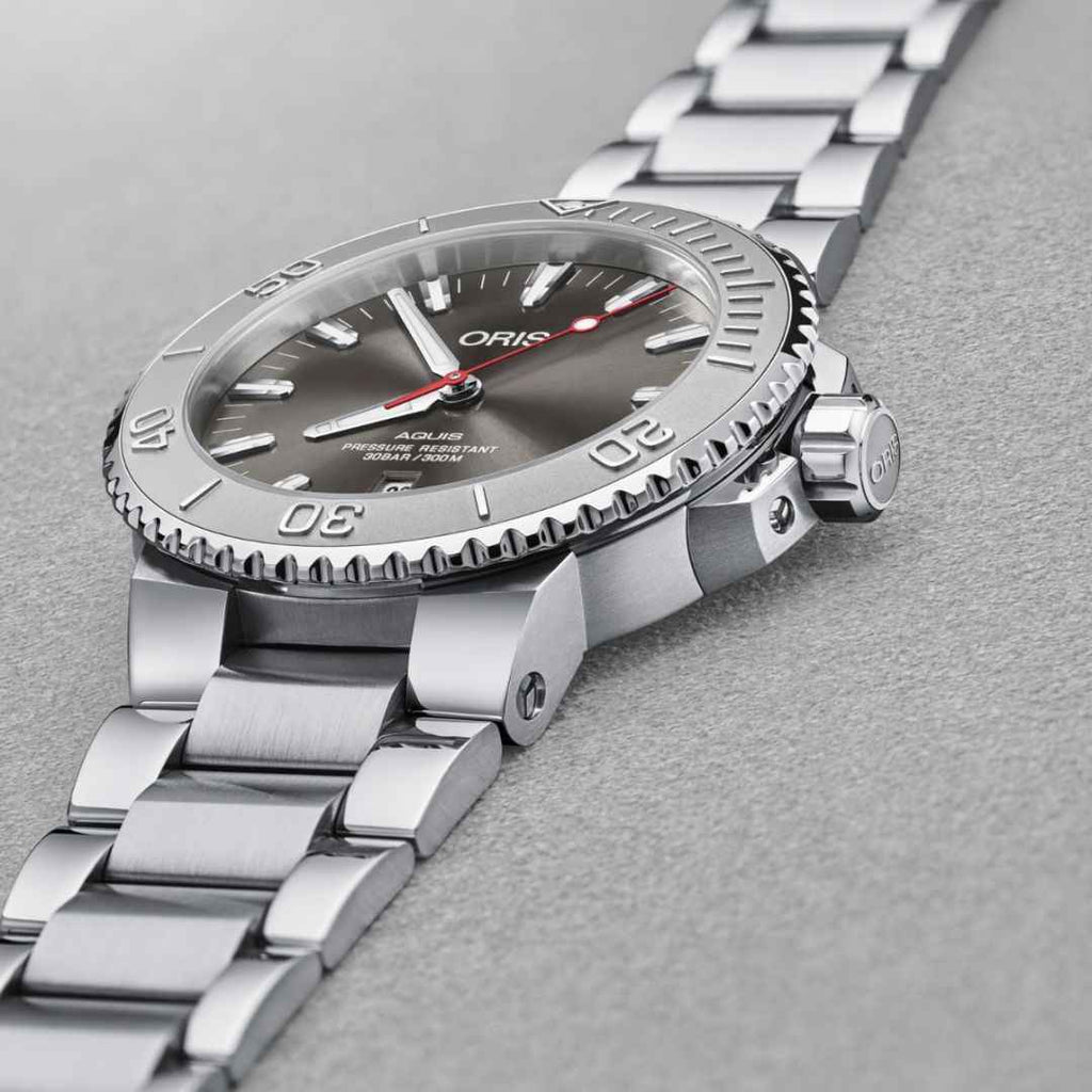 Orologio subacqueo in acciaio con quadrante grigio, lancette rosse e ghiera zigrinata