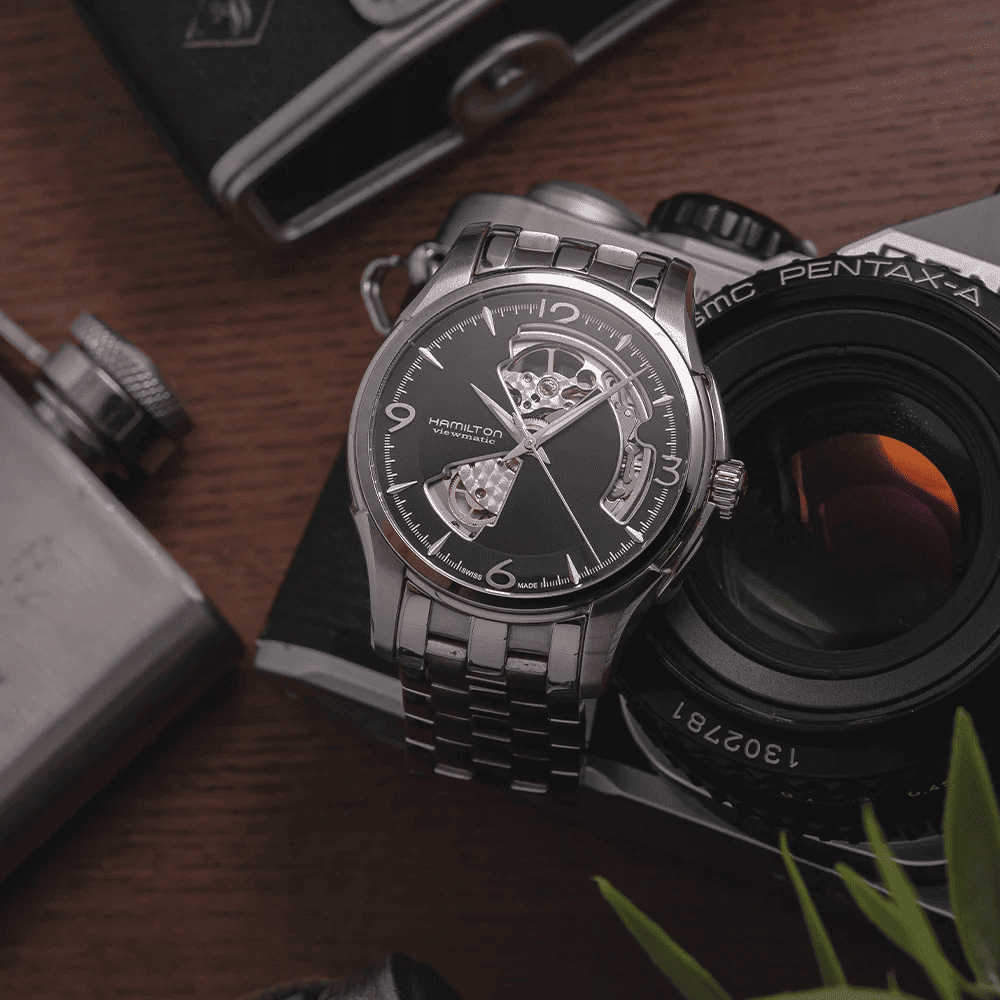 Orologio automatico con quadrante nero scheletrato e bracciale d’acciaio, vista laterale