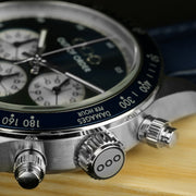 Dettaglio dell’orologio: ghiera blu con indicazioni, pulsanti cromati e cinturino in pelle blu.