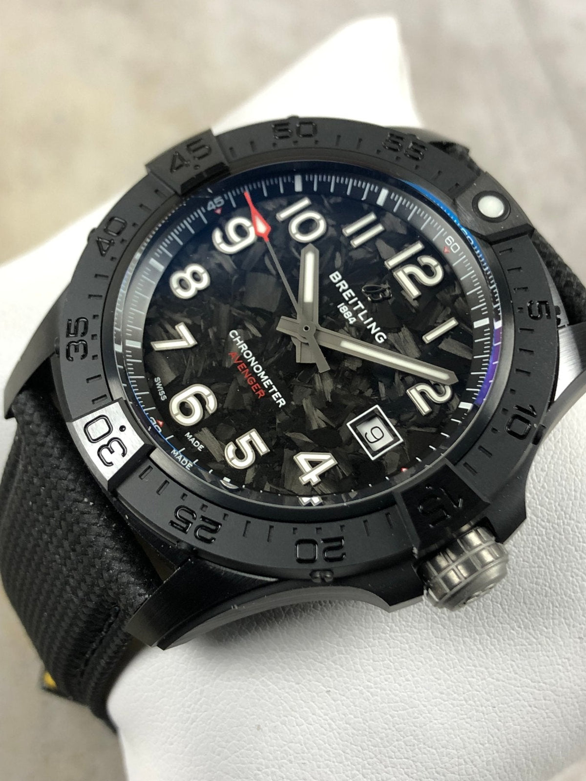 Orologio Breitling con quadrante nero e lancette rosse, cinturino nero tessitura, cassa scura