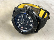 Orologio Breitling con quadrante blu/nero e indici bianchi, cinturino nero con interno giallo