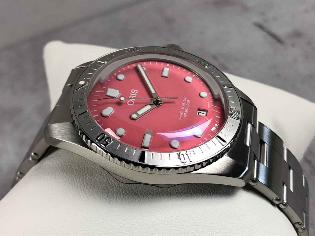 Orologio subacqueo ORIS con quadrante rosso e lunetta nera zigrinata, bracciale in acciaio.