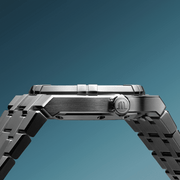 Orologio automatico con cassa in acciaio e corona laterale, cinturino turchese.