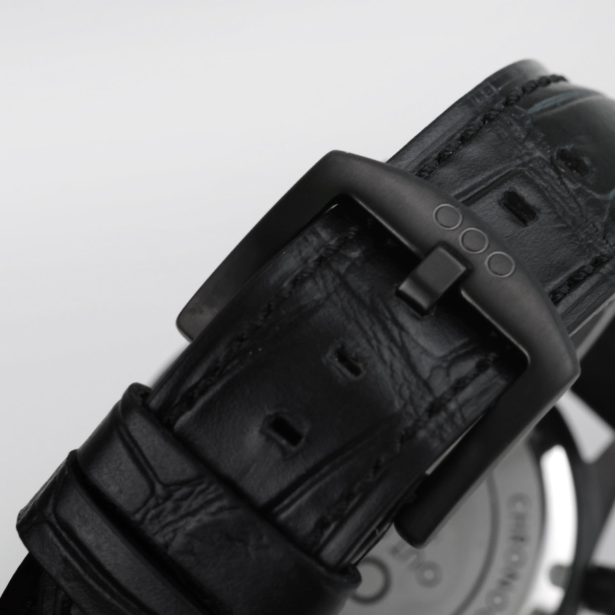 Cinturino in pelle nera con fibbia e passanti, texture in rilievo e chiusura scura