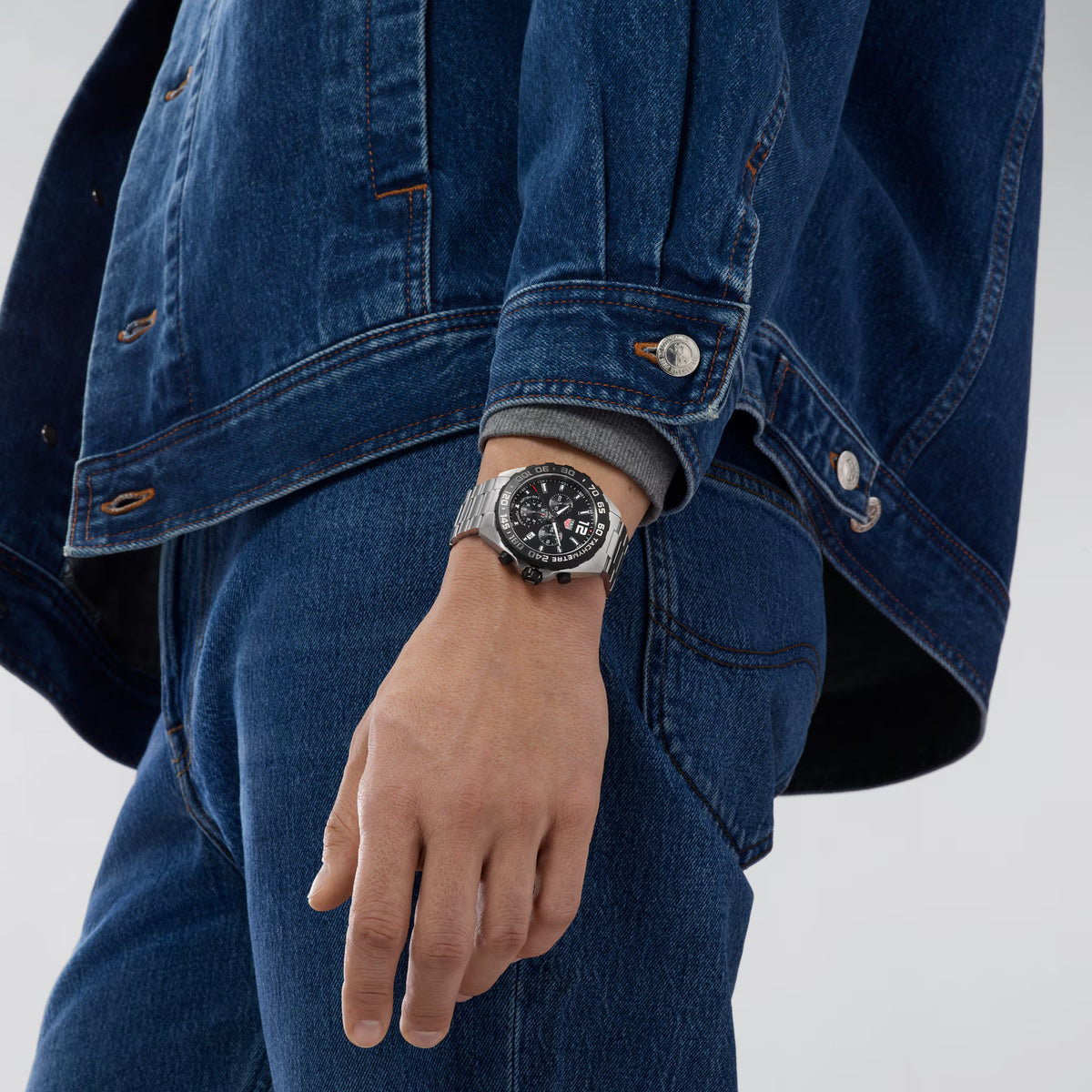 Orologio cronografo TAG Heuer Formula 1 al polso, quadrante nero, cinturino d'acciaio.