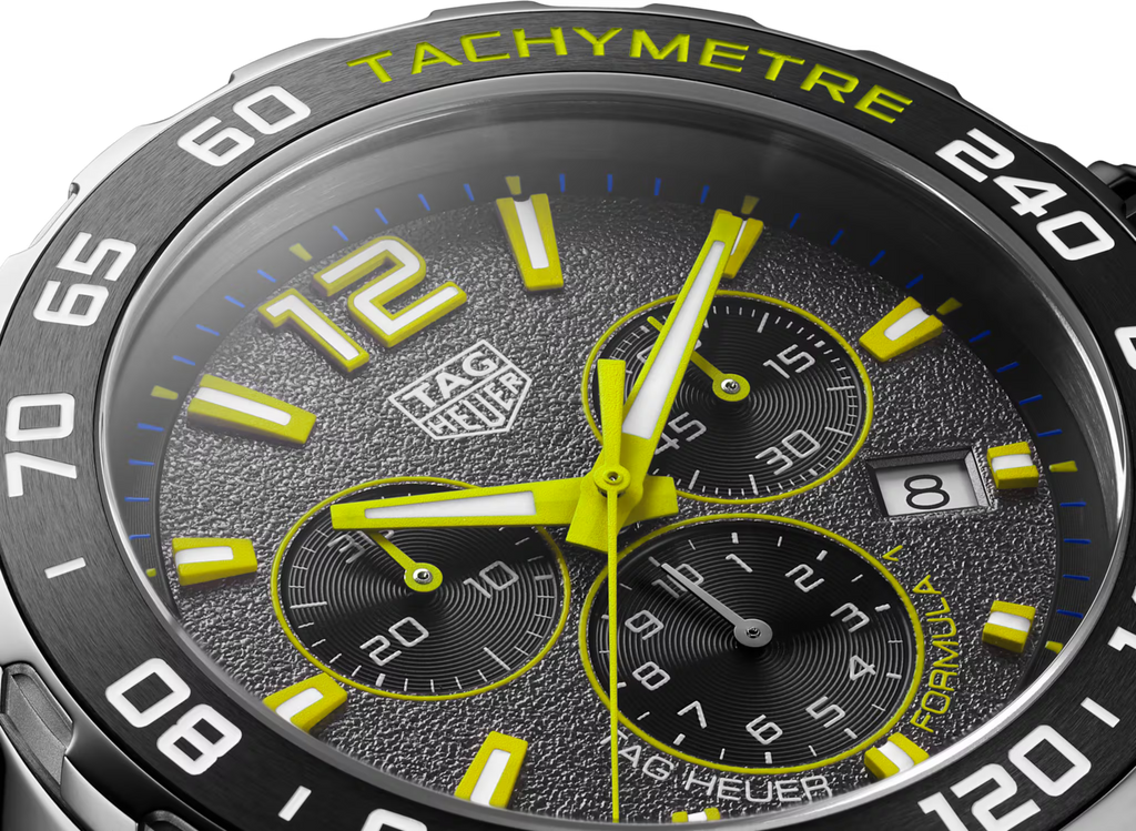 Quadrante grigio con cronografi e tachimetro, numeri giallo lime e indici luminosi.