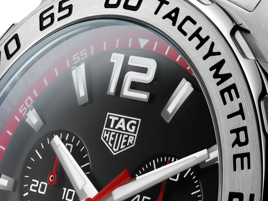Orologio TAG Heuer: lunetta fissa e quadrante nero con numeri bianchi e dettagli rossi.
