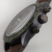 Orologio cronografo con cassa in metallo e pulsanti laterali, cinturino marrone.
