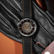 Orologio con quadrante fumé e cinturino nero tessuto, dettagli arancioni sulla ghiera