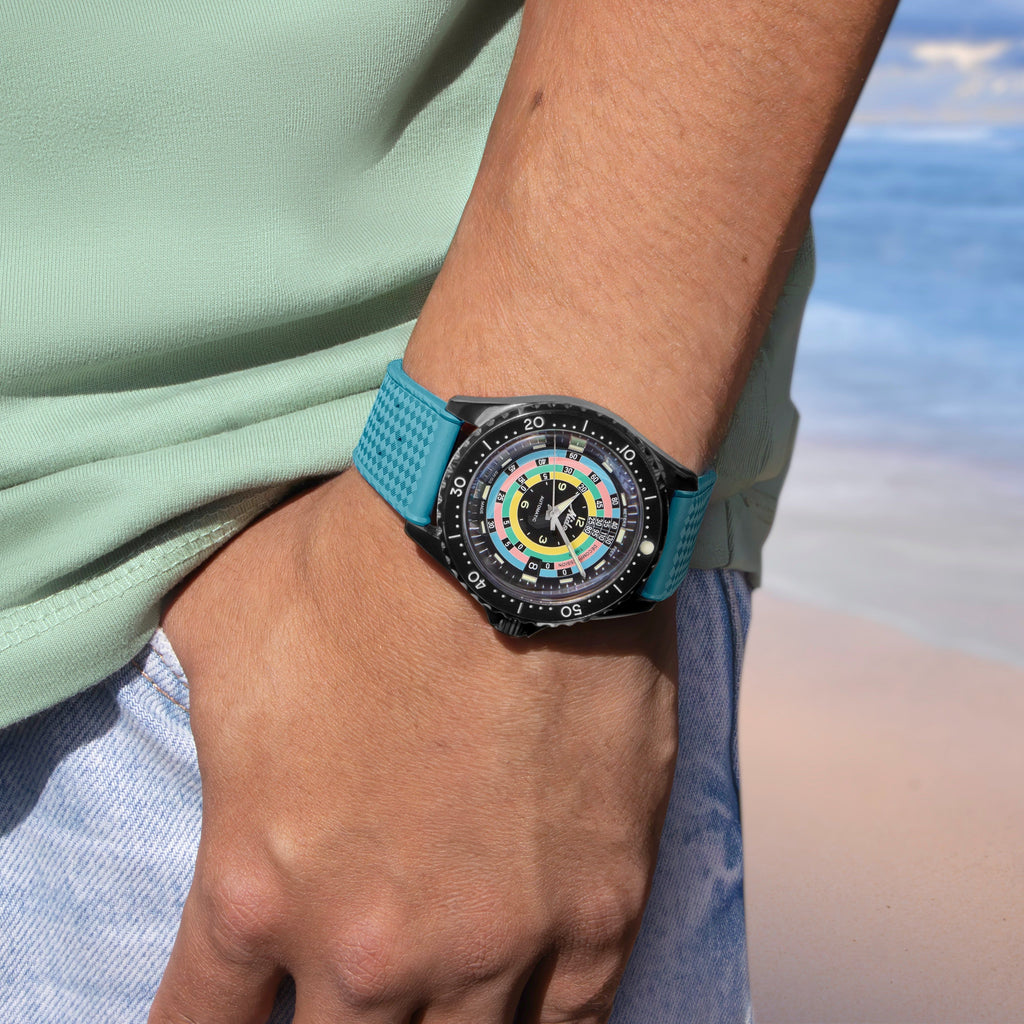 Orologio con cinturino azzurro e quadrante multicolore su polso