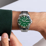Orologio al polso con quadrante verde, lunetta verde e bracciale acciaio