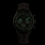 Orologio cronografo con quadrante verde luminescente e cinturino marrone.