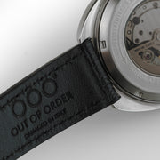 Cinturino in pelle nera con cuciture e scritta “Out Of Order”.