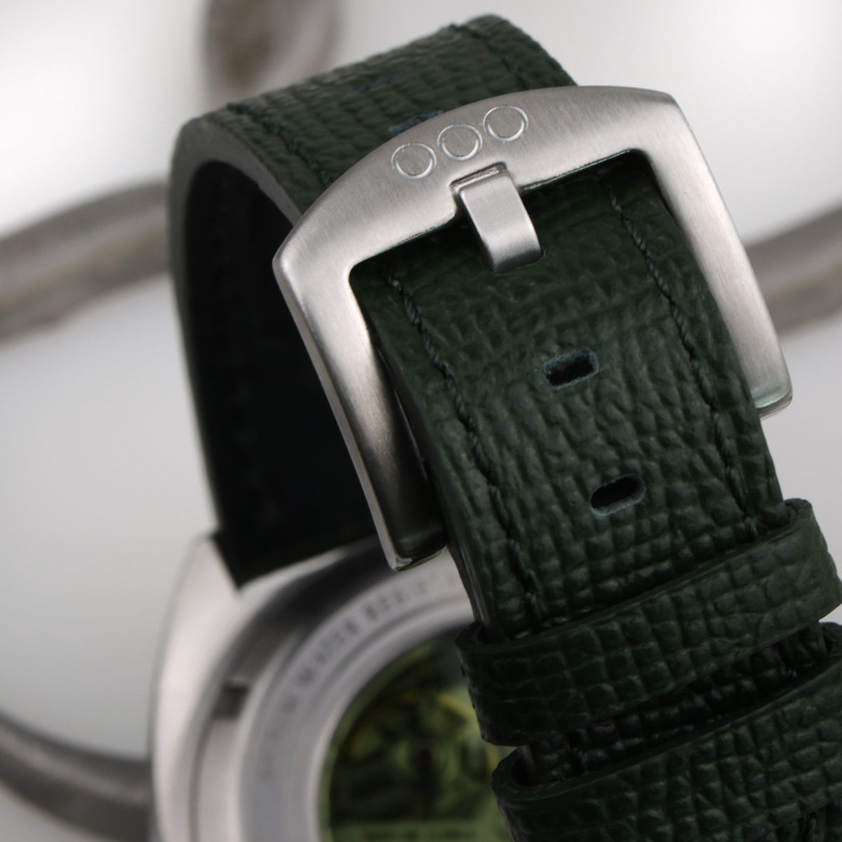 Fibbia e cinturino in pelle verde dell’orologio automatico con cassa in acciaio.
