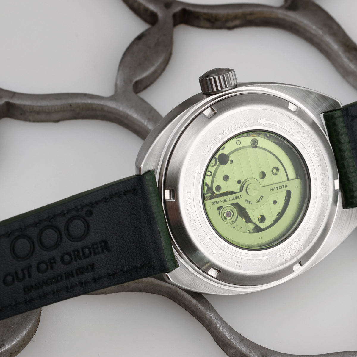 Fondello dell’orologio automatico in acciaio con movimento verde e cinturino in pelle verde.
