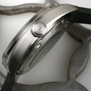 Cassa in acciaio e corona dell’orologio automatico, con cinturino in pelle verde.