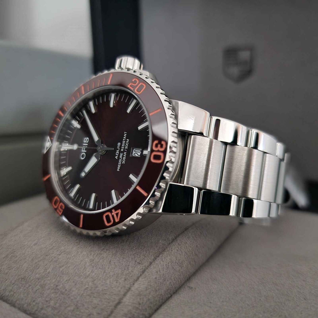 Orologio subacqueo con quadrante marrone e bracciale acciaio, lunetta con numeri rossi