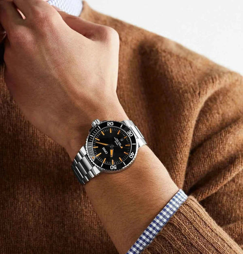 Orologio sub Oris Aquis con bracciale in acciaio, quadrante nero e indici arancioni
