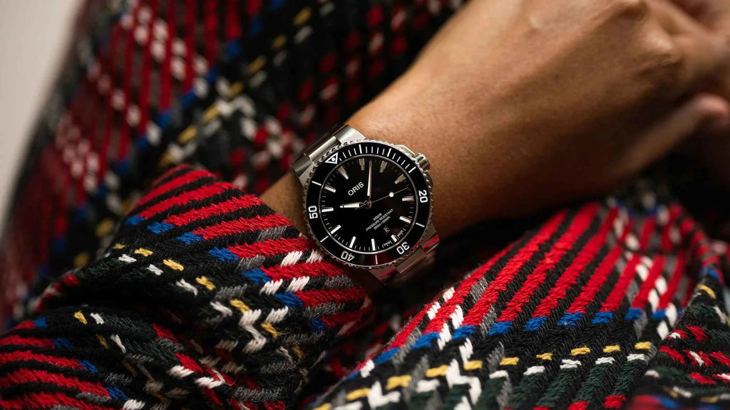 Orologio sub acciaio con quadrante nero, data visibile e bracciale maglia