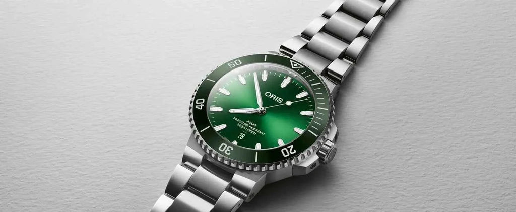 Orologio con quadrante verde e bracciale in acciaio, vista inclinata.