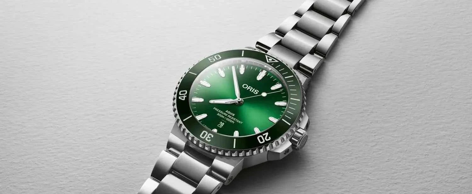 Orologio con quadrante verde e bracciale in acciaio, vista inclinata.