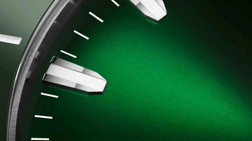 Dettaglio del quadrante verde con indici e cassa in acciaio dell’orologio.