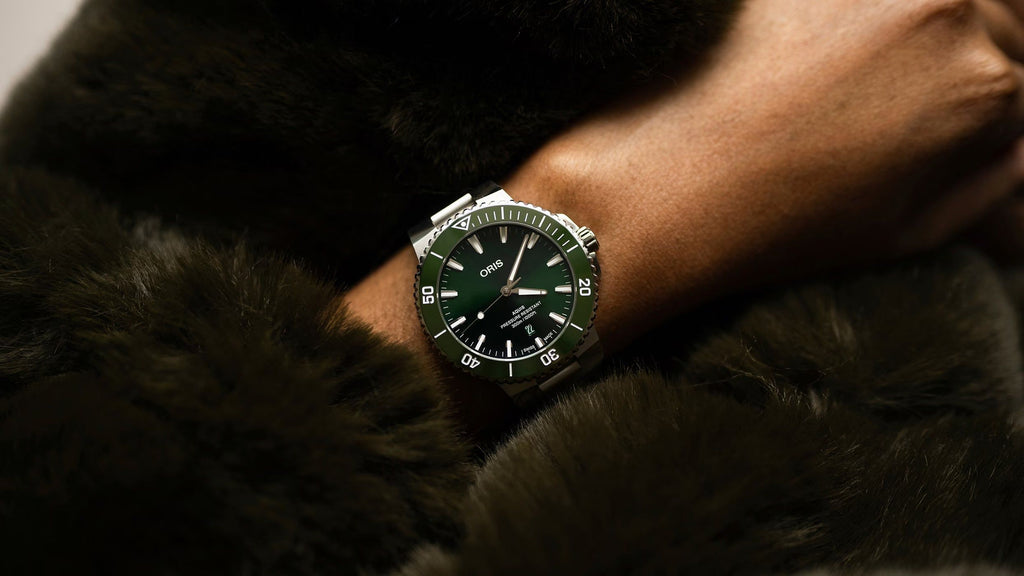 Orologio subacqueo con quadrante verde al polso e bracciale in acciaio