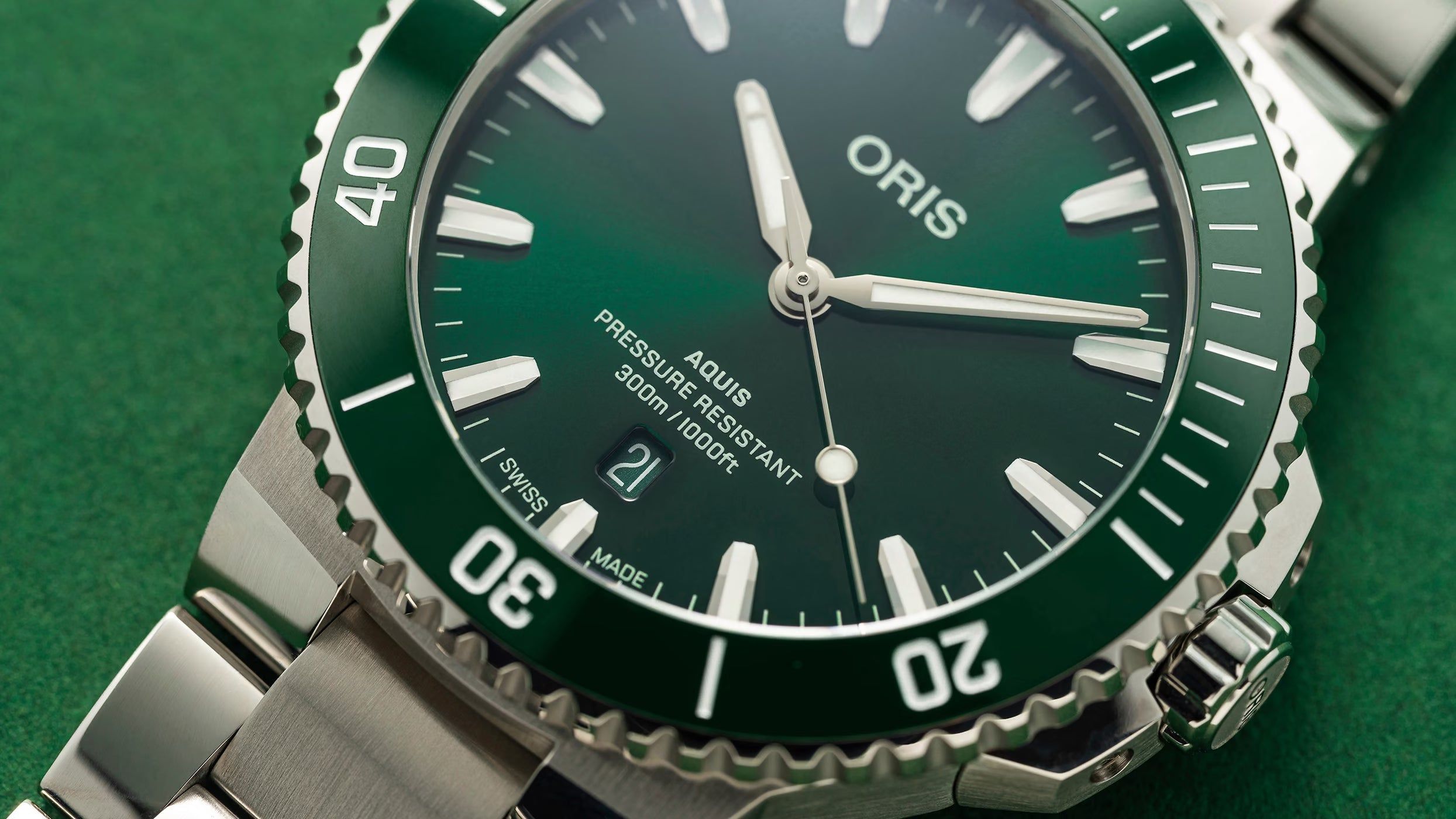 Primo piano: quadrante verde con lancette e logo ORIS, ghiera con numeri