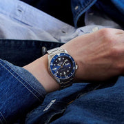 Orologio Seiko al polso con quadrante blu, lunetta blu e bracciale in acciaio
